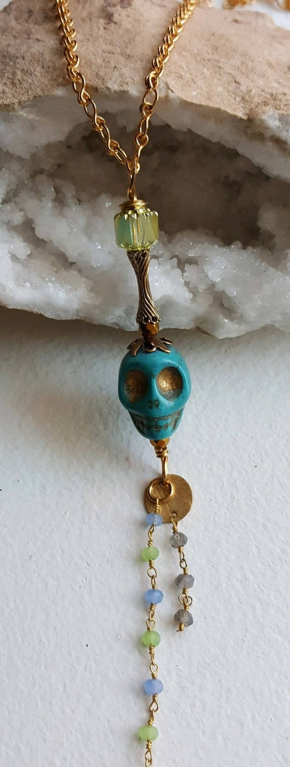 Turquoise howlite carved skull, brass bead cap, dangling chalcedony chain, on gold plated chain